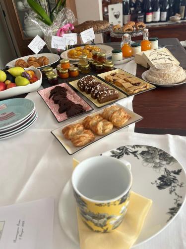 a table with various pastries and a cup of coffee at Albergo & Ristorante Selvatico in Rivanazzano