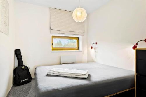 a bedroom with a bed with a suitcase and a window at JB227-Frostrup-Andreas-Lassens-Vej-16 in Nørklit