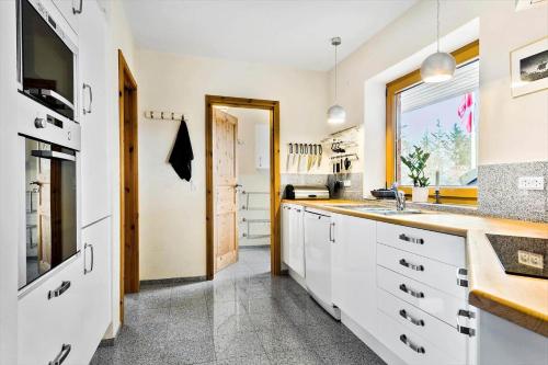 a kitchen with white cabinets and a window at JB227-Frostrup-Andreas-Lassens-Vej-16 in Nørklit
