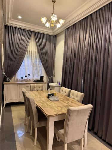 a dining room with a table and chairs at AHIL apartments in Kano