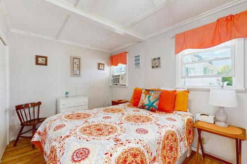 sypialnia z łóżkiem z pomarańczowymi poduszkami i oknem w obiekcie Lil' Cottage Retreat w mieście York
