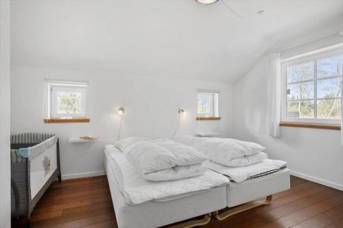 a white bedroom with a bed with white sheets at JB228-Brovst-Ildervej-14 in Tranum