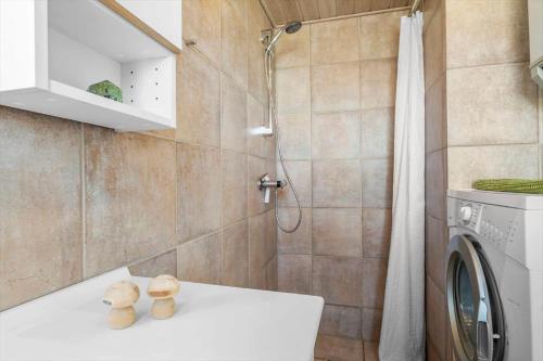 een badkamer met een wasmachine en een douche bij JB230-Frostrup-Grabakkevej-4 in Lild Strand