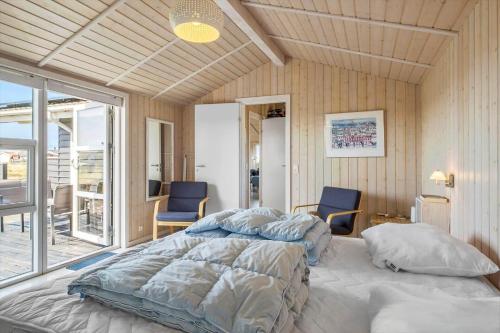 een slaapkamer met een bed en twee blauwe stoelen bij JB230-Frostrup-Grabakkevej-4 in Lild Strand