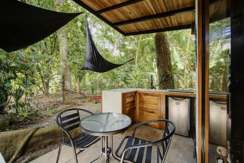 a patio with a table and chairs on a porch at Casita SAMSARI in Punta Uva