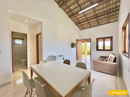 a dining room with a table and chairs and a couch at Clube Mirante do Iguape in Aquiraz