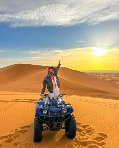 a person on a four wheeler in the desert at Aladdin merzouga camp in Merzouga