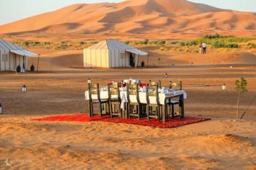 a table in the middle of a desert at Aladdin merzouga camp in Merzouga