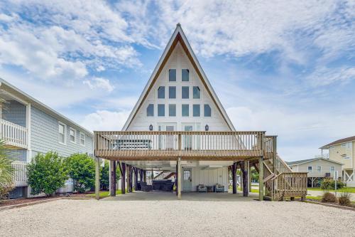 a house with a triangular roof with a deck at Unique A-Frame Beach House The Beacon at OIB in Ocean Isle Beach