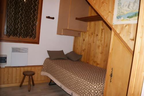 a small bed in a room with a staircase at Appartement La Petite Cascade in Allos