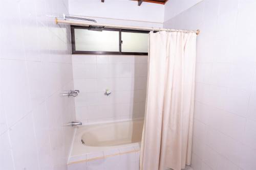 a bathroom with a tub and a shower curtain at Best Western Las Mercedes Airport in Managua