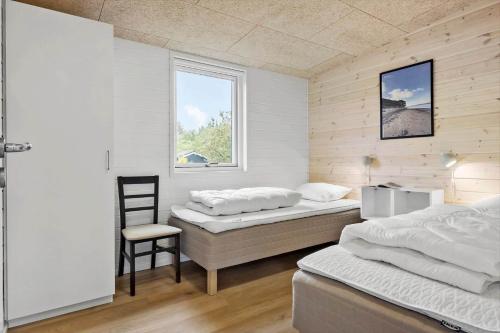 una camera da letto con due letti e una sedia di JB350-Fjerritslev-Egevej-9 a Fjerritslev