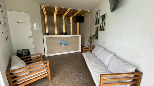a living room with a couch and a flat screen tv at Bungalow Jatun Mama in Ventanilla