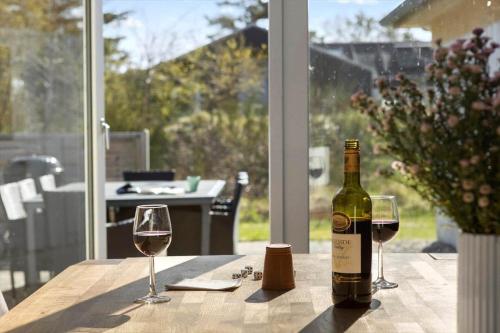 a bottle of wine sitting on a table with two glasses at JB149-Fjerritslev-Tulipanvej-23 in Slettestrand