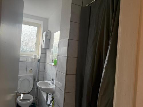 a bathroom with a toilet and a sink at K&K Unterkunft Gelsenkirchen in Gelsenkirchen
