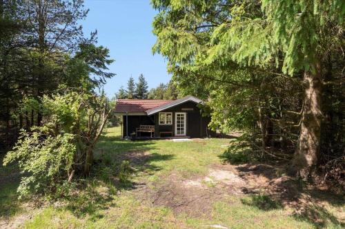a small cabin in the woods with a yard at JB353-Brovst-Hjortevaenget-13 in Bratbjerg