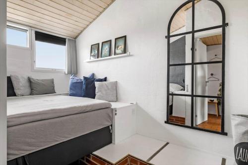 a bedroom with a bed and a mirror at JB358-Brovst-Strandvejen-150-Lejl-126 in Tranum Strand