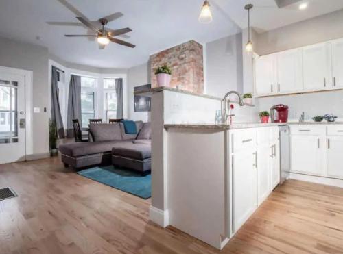 an open kitchen and living room with a couch at Jungle House Columbus Downtown Free Parking Sleeps 8 - Near Convention Center & Nationwide Arena - 2BR Short North Luxury Home - Over 5,800 Five Star Stays in Columbus