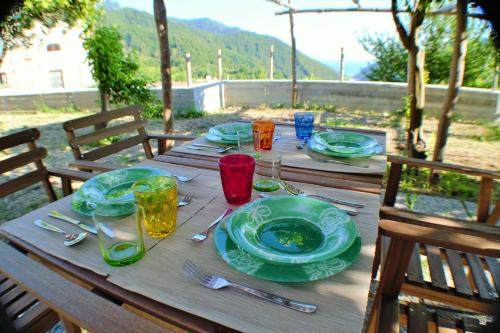 a wooden table with plates and glasses on it at Montammare Casa Di Charme in Tramonti