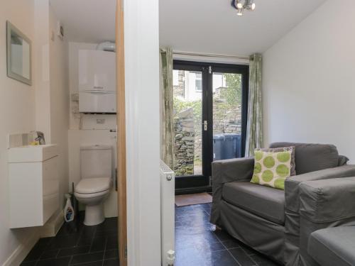 ein Wohnzimmer mit Couch und Toilette in der Unterkunft Cloud Cottage in Ambleside