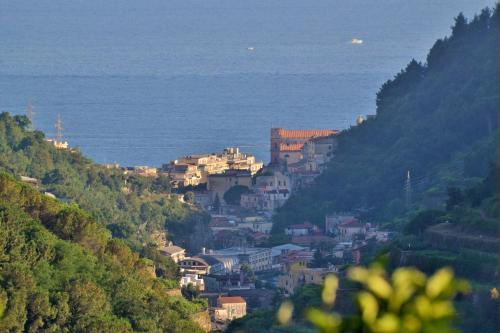 a town on a hill with the ocean in the background at Montammare Casa Di Charme in Tramonti