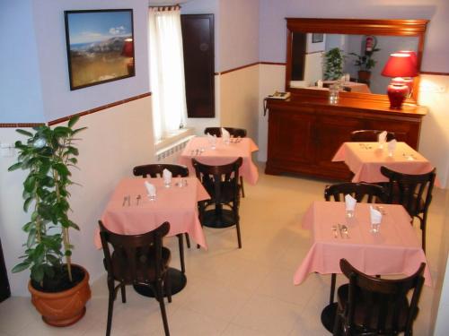 un restaurante con mesas y sillas rosas y una planta en Hotel Fitu, en Colunga