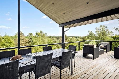 a wooden deck with a table and chairs on it at JB400-Brovst-Solsortevej-7 in Tranum