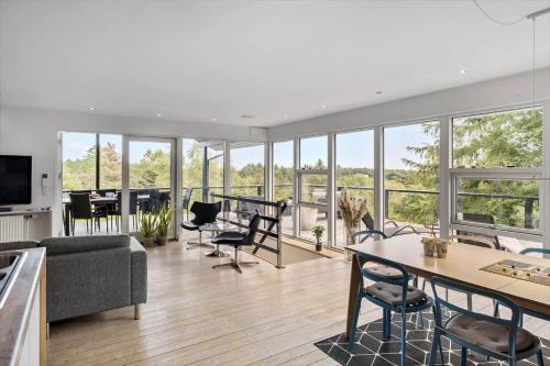 a living room with a couch and a table and chairs at JB400-Brovst-Solsortevej-7 in Tranum