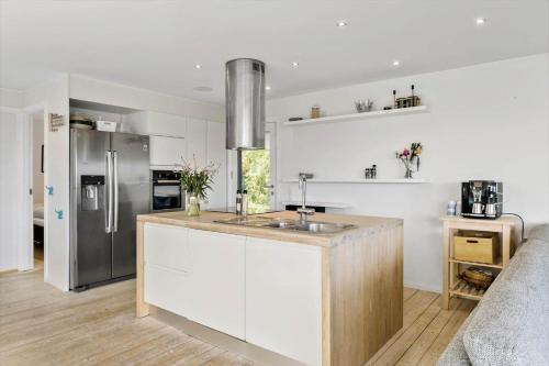 a kitchen with white cabinets and a stainless steel refrigerator at JB400-Brovst-Solsortevej-7 in Tranum