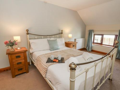 a bedroom with a large white bed with white sheets at Glanyrafon in Rhayader