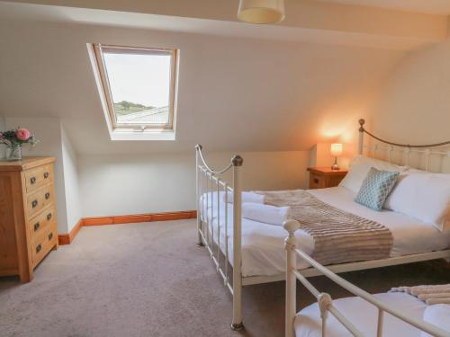 a bedroom with two beds and a window at Glanyrafon in Rhayader