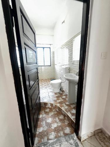a bathroom with two toilets and a sink at jahazi homes -watamu in Watamu