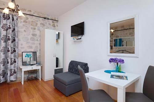 a living room with a white table and a chair at Festa Apartments & Rooms in Dubrovnik