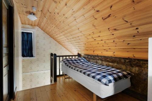 a bed in a room with a wooden ceiling at KAL344-Nybro-Krumhall-110 in Florhult