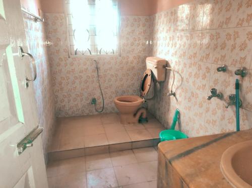 un baño con inodoro y lavabo en El Dorado Inn, en Guwahati