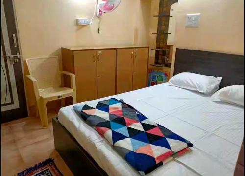 a bedroom with a bed with a quilt on it at Malnadu home stay Haandi in Aldūr