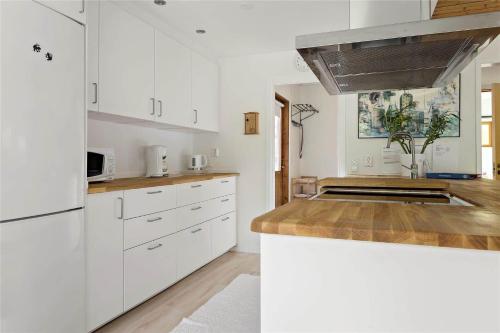 a kitchen with white cabinets and a counter top at OST428-Moensteras-Ekeholmsvaegen-7 in Stora Oknö