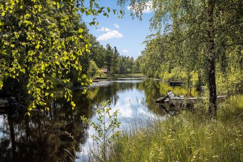 a river with a person sitting on a boat in the water at KAL591-Hoegsby-Allgunnen-113 in Skurebo