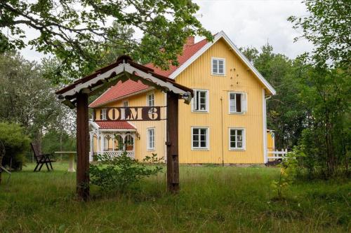 a yellow house with a sign in front of it at KAL558-Virserum-Holm-6 in Holm