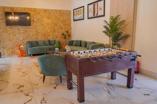 a living room with a foosball table and chairs at The Uptown Kingdom Luxury Homestay in Mukteswar