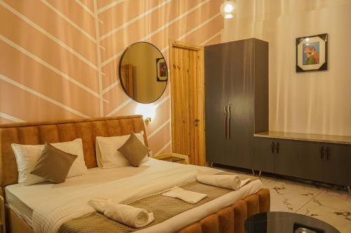 a bedroom with a bed with a mirror on the wall at The Uptown Kingdom Luxury Homestay in Mukteswar