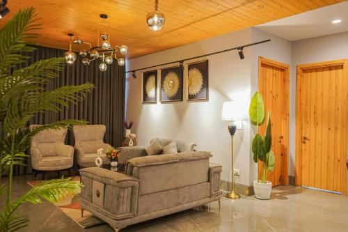 a living room with a couch and two chairs at The Uptown Kingdom Luxury Homestay in Mukteswar