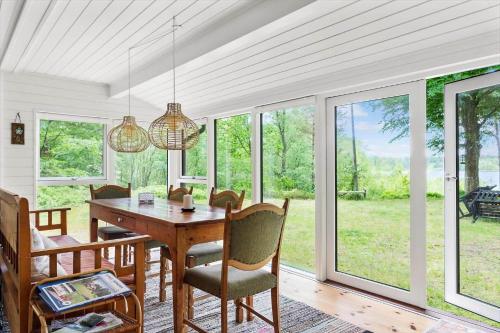 a dining room with a table and chairs and windows at SKA566-Vaestra-Torup-Oejesjoevaegen-9 in Västra Torup