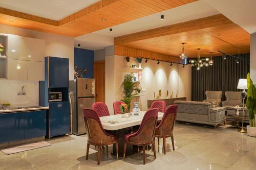 a kitchen and dining room with a table and chairs at The Uptown Kingdom Luxury Homestay in Mukteswar