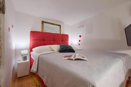 a bedroom with a large bed with a red headboard at Festa Apartments & Rooms in Dubrovnik