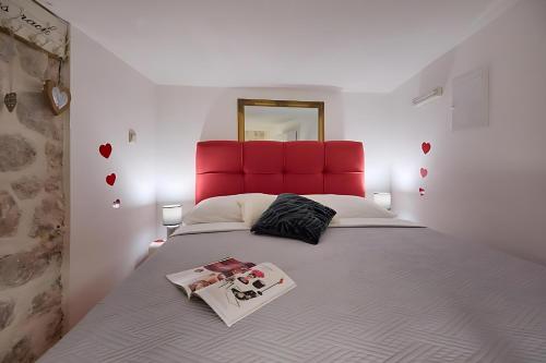 a bedroom with a large bed with a red headboard at Festa Apartments & Rooms in Dubrovnik