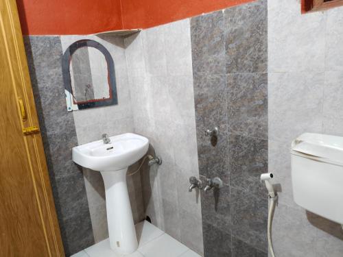 a bathroom with a sink and a toilet at Gate way resort in Purbbadulki