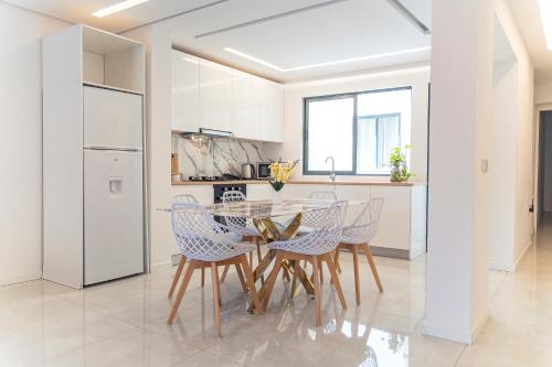 a dining room with a table and chairs in a kitchen at 3-bdr apt 10-min walk laginha beach - LCGR in Mindelo