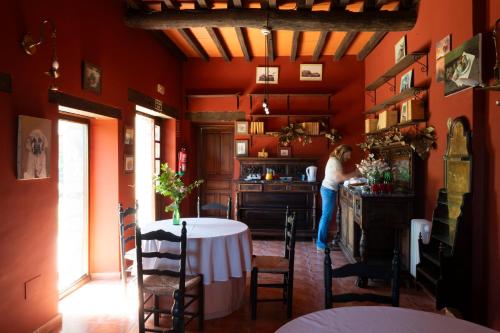 a woman standing in a kitchen with a table in a room at Hotel rural El Jardin del Conde in Puerto de Béjar