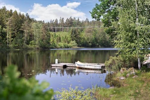 a small boat on a dock on a lake at BLE624-Olofstroem-Hemsjoehultsvaegen-86 in Hemsjöhult